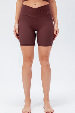 Cross-waist bike shorts in Burgundy with ribbed texture and side pockets.