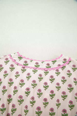 Floral v-neck midi dress in blush pink with scalloped trim and button front detail.