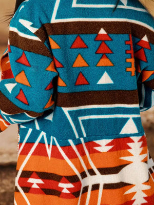 Southwestern print shawl collar jacket in peacock blue with geometric and triangle patterns.