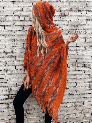 Terracotta hooded fringed knit cape with diagonal stripe pattern and textured acrylic weave.
