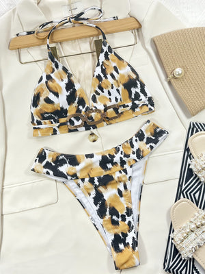 White leopard print bikini with chain detail on top and matching bottoms.