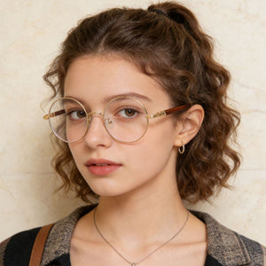 Round frame glasses with clear lenses and gold metal rims with wood-look temples.
