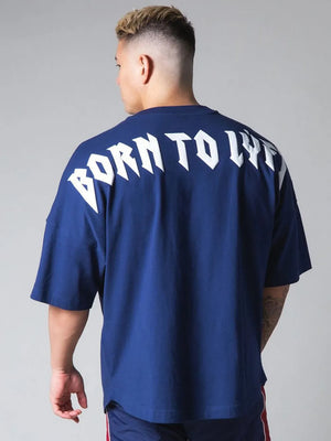 Royal blue oversized graphic tee with white "BORN TO LIVE" text on back.