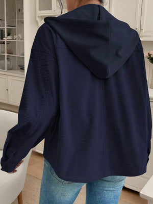 Dark navy waffle knit hooded jacket with buttoned cuffs and drawstring hood.