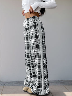 Plaid wide-leg track pants in black with white and gray plaid pattern and a gray side stripe.