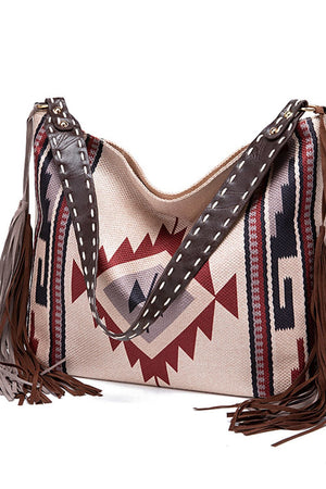Southwestern fringe hobo bag in beige canvas with geometric pattern and leather straps.