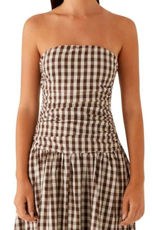 Ruched strapless maxi dress in brown and white gingham with a flowing skirt.