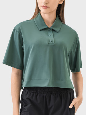 Cropped polo shirt in green with short sleeves and button placket.