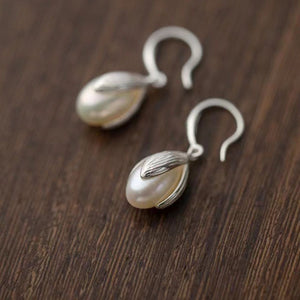 Lustrous pearl drop earrings with silver setting and hook clasps.
