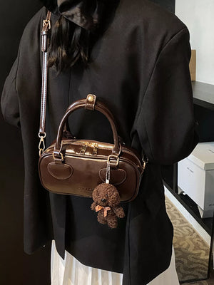 Chic mini crossbody bag in chocolate PU leather with a teddy bear charm.