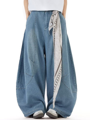 Men's wide leg jeans in light wash denim with a patterned tie belt detail.