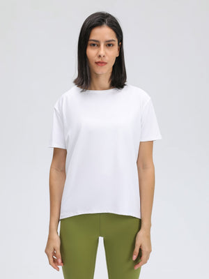 White relaxed fit performance tee with short sleeves and a crew neck, shown on a model.