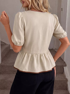 Beige V-neck blouse with short puff sleeves and ruffle hem, trimmed in brown