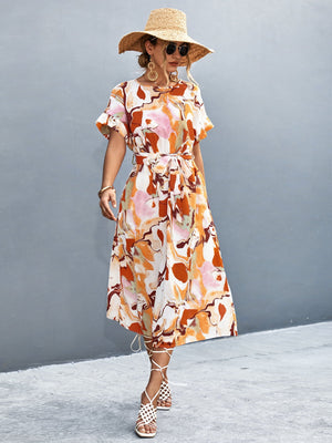 Women's abstract print midi dress with tie waist, short sleeves, and A-line cut in orange-red and blue tones.