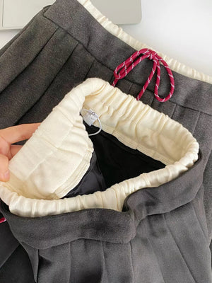 Dark gray pleated skirt with drawstring waist and cream lining