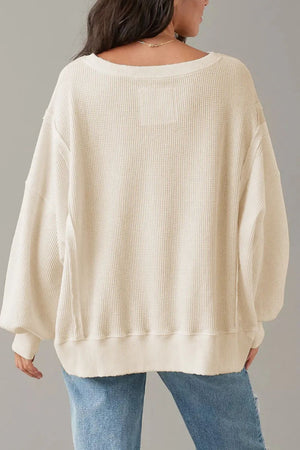 Waffle knit pullover sweater in ivory with slit sleeves and a relaxed fit.