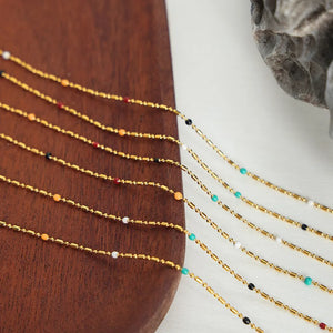 Gold necklace with colorful beads and bar accents, delicate chain detail
