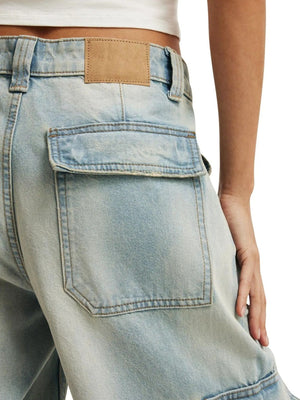 Light blue denim cargo pants with buttoned flap pocket and leather patch detail.
