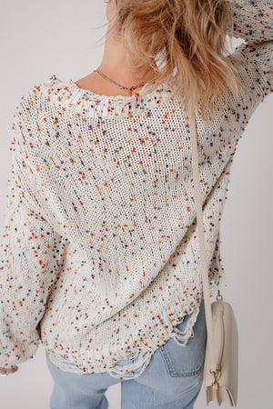 Confetti knit sweater in white with colorful flecks, distressed hem, and frayed neckline.