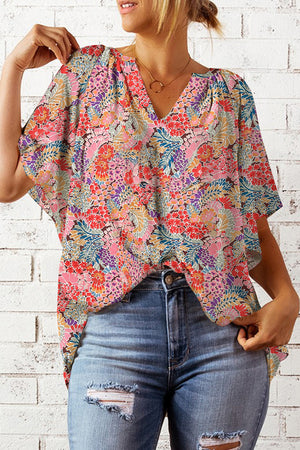 Floral dolman sleeve v-neck blouse with a colorful bloom pattern.
