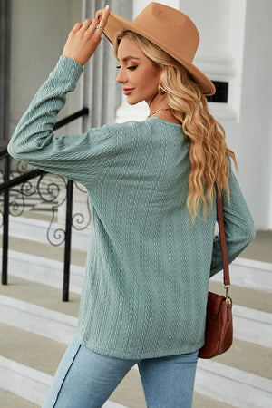 Textured cable-knit henley pullover in light blue with long sleeves and a crew neck.