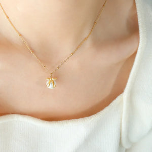 Gold bow-adorned pearl drop necklace with beaded chain detail.