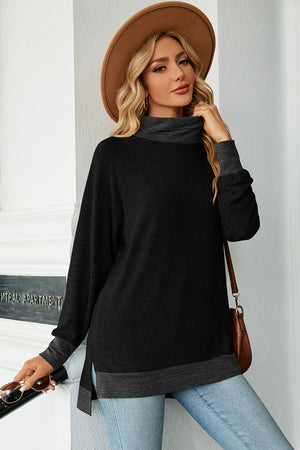 Colorblock raglan turtleneck tunic in black with dark gray accents, featuring a relaxed fit and side slits.
