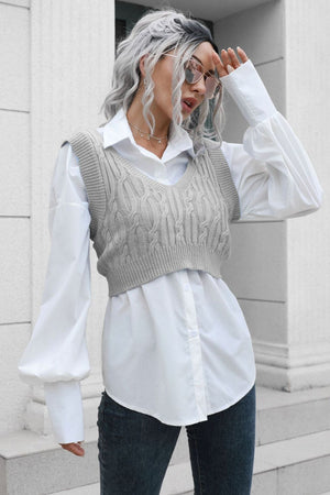Gray cropped cable knit V-neck vest with a white button-up shirt.