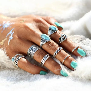 Bohemian silver rings with turquoise stones and intricate patterns on a hand.