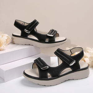 Black adjustable open-toe sandals with contrast stitching and hook-and-loop straps.