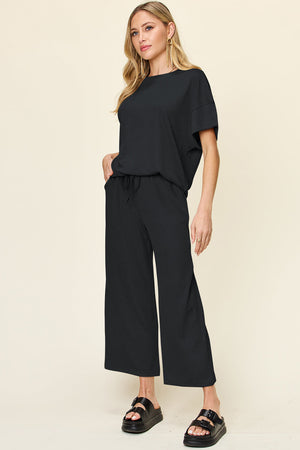 Black waffle knit lounge set with drawstring pants and short sleeve top.