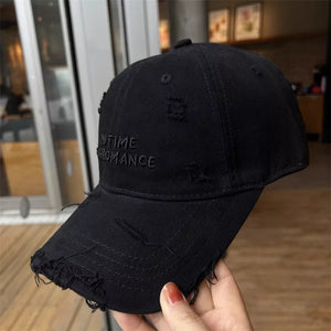 Black distressed cotton baseball cap with embroidered text and frayed brim.