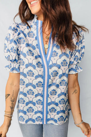 Playful floral puff sleeve blouse with V-neck and ruffled cuffs in blue and white pattern.