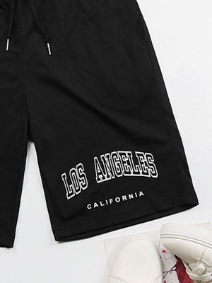 Black jogger shorts with "Los Angeles California" graphic print and drawstring waist.