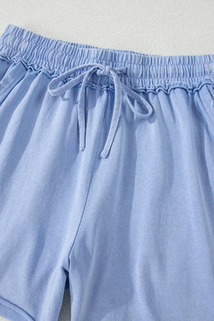 Light blue acid-washed cotton drawstring shorts with pockets and elastic waistband.