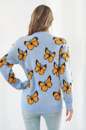 Pastel blue acrylic knit crewneck pullover with allover orange butterfly motif and textured details.