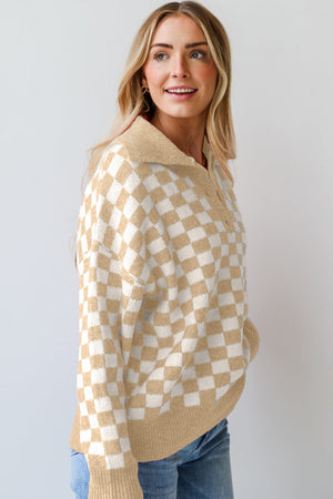 Tan and white checkerboard knit polo sweater with button detail.