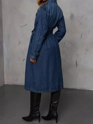 Dark denim trench coat with belted waist and button details.