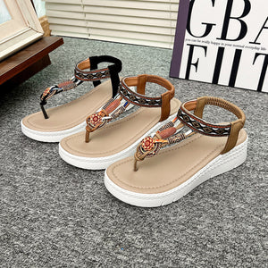 Ethnic patterned wedge sandals with floral accents and ankle straps in khaki and black.