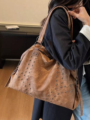 Brown distressed studded trapezoid handbag with vintage look