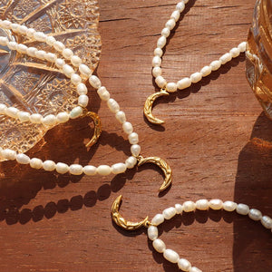 Gold crescent moon pearl necklaces with delicate pearl strands.