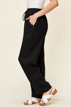 Black textured gauze relaxed drawstring trousers with side pockets