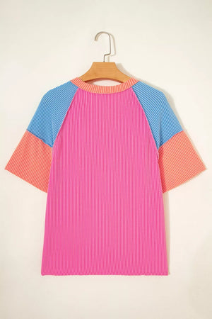 Vibrant ribbed V-neck t-shirt with color block sleeves in pink, blue, and orange.