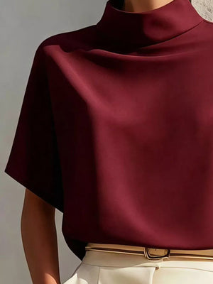 Burgundy mock neck t-shirt with relaxed sleeves and draped neckline.