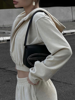 Apricot cropped zip hoodie and wide leg sweatpants set with a black shoulder bag