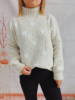 Cream acrylic turtleneck sweater with a textured knit and subtle heart pattern.