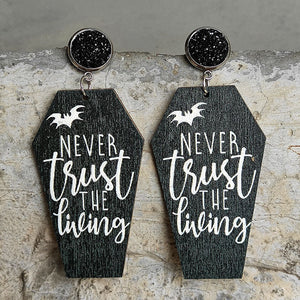 Gothic coffin earrings with white text "Never trust the living" and bat graphic.