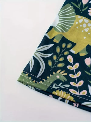 Dinosaur print elastic waist skirt in dark blue with green, pink, and yellow botanical accents.