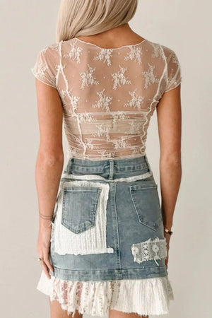 Sheer beige ruched maternity shirt with floral embroidery and short sleeves.