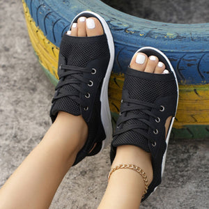 Black lace-up wedge sandals with mesh uppers and open toe.